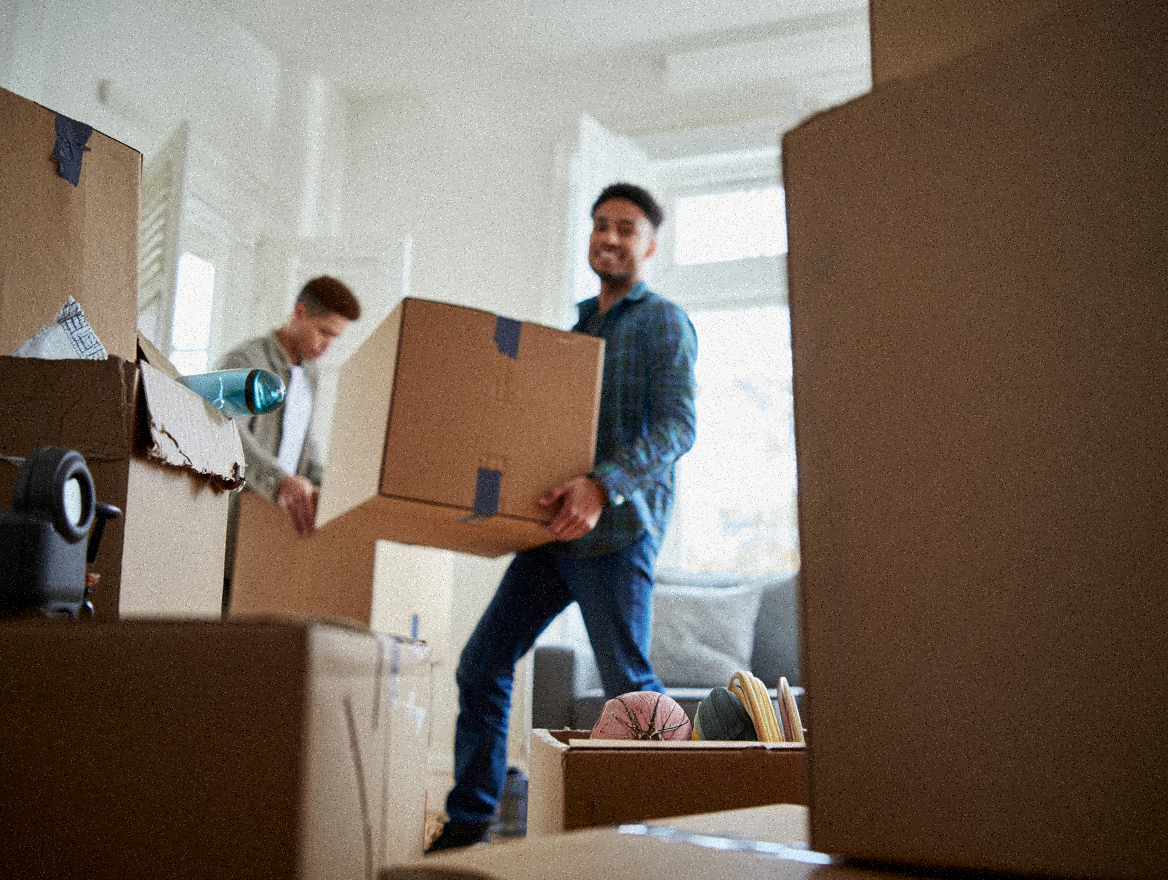 Movers carrying packed box from the living room to the moving truck