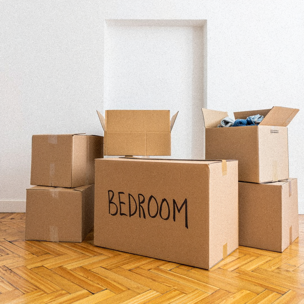 Packed moving boxes stacked in a living room ready for relocation.