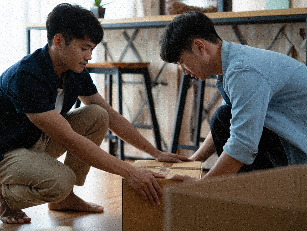 Two man preparing to carry a box after packing